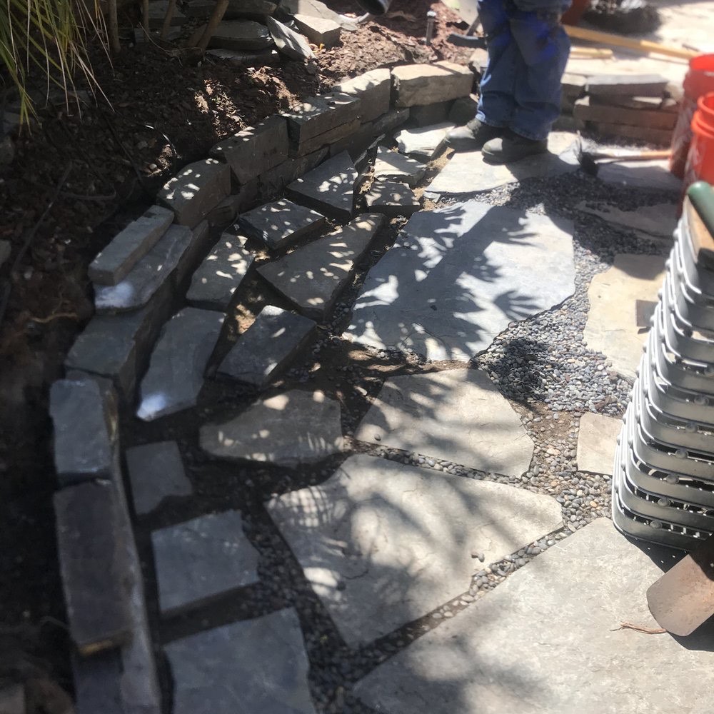 Stone edging being installed along a garden bed