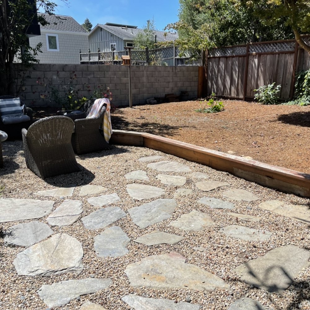 Stone and gravel patio with a wood retaining border